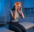 Young woman holding her temples, experiencing a headache.