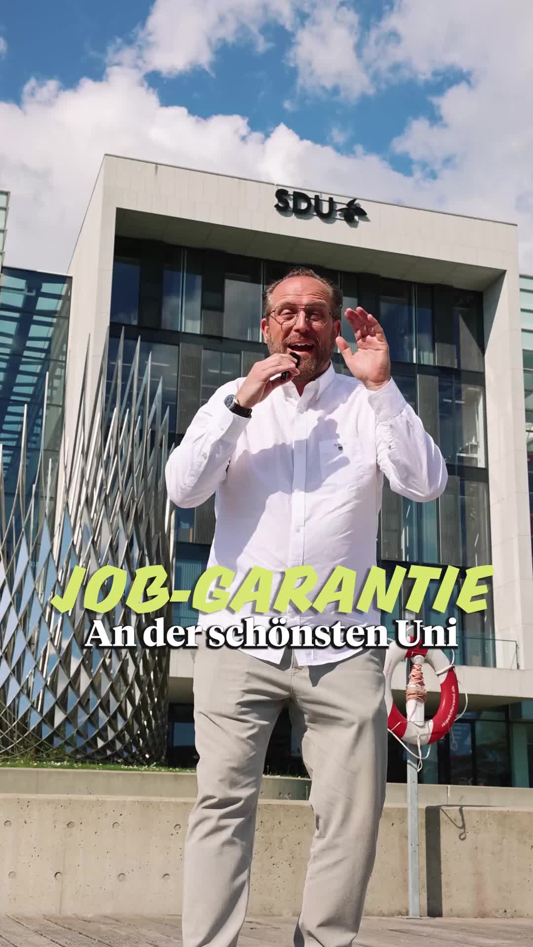 Mr.Karriere vor einem Gebäude des SDU Campus am Wasser