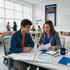 A teacher and student review financial planning documents in a bright classroom with an "Education Opens Doors" poster.