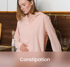 Young woman holding her stomach in discomfort due to constipation, addressed through holistic digestive health solutions.