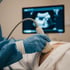 Ärztliche Hand führt eine Ultraschallsonde ergonomisch am Bauch