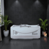 Weiße Whirlpool-Badewanne in einem modernen Badezimmer mit dunklen Fliesen und Pflanzen.