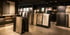 Fliesenausstellung mit verschiedenen großformatigen Fliesen in Regalen und Ständern, beleuchtet von Deckenspots.