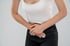 Woman holding lower abdomen with both hands