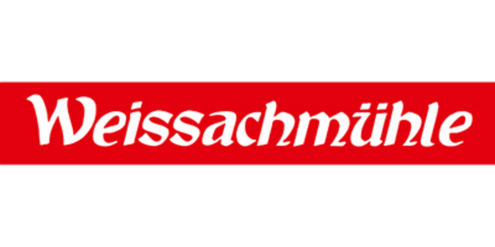 Rotes Banner mit weißer Schrift "Weissachmühle" auf grünem Hintergrund.