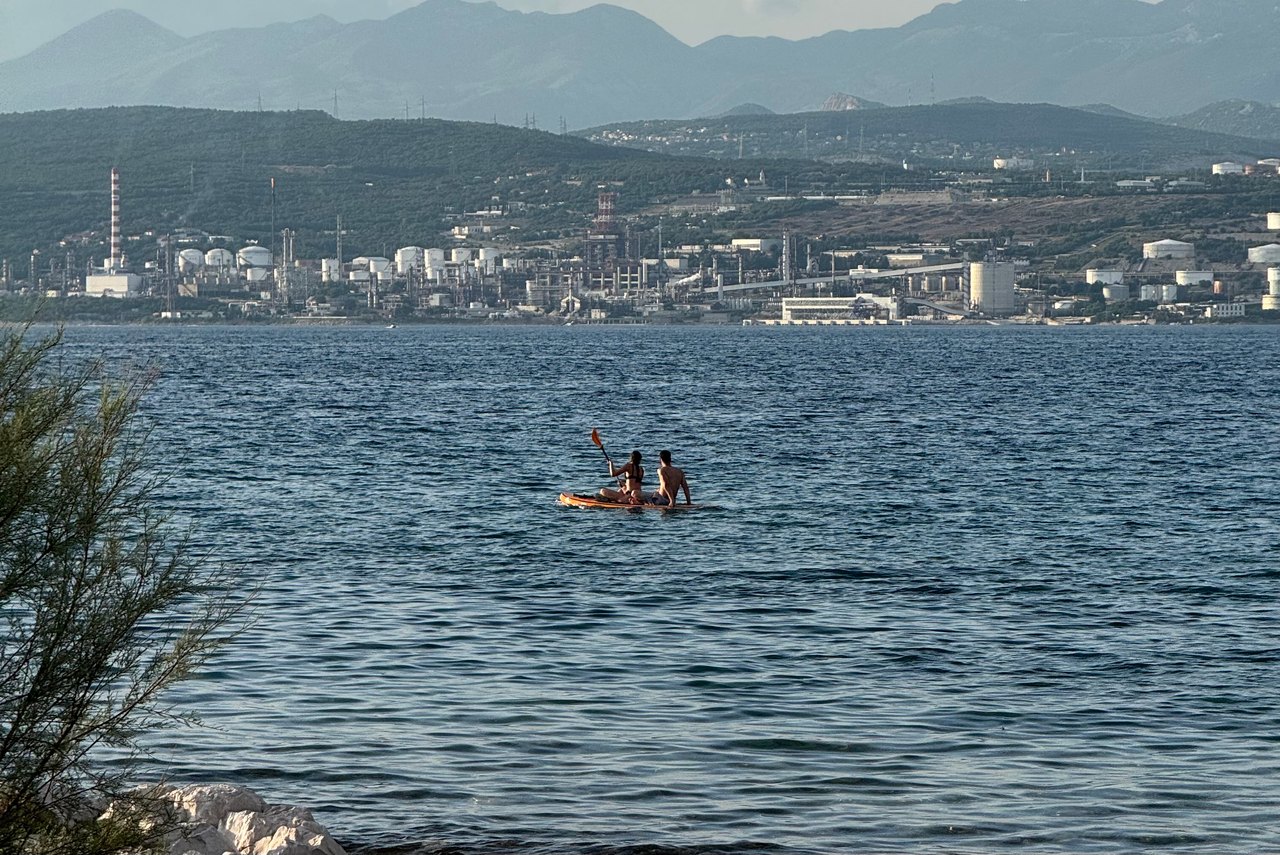 Two people on a paddleboard on a wide calm bay