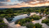 Infinity-Pool umgeben von Lavendel und Grünpflanzen in einer Hügellandschaft bei Sonnenuntergang.