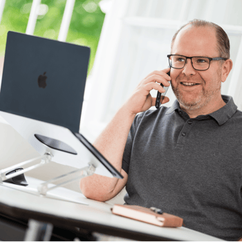 Florian Müller telefoniert am Schreibtisch.