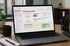 Laptop auf einem Schreibtisch zeigt das Dashboard einer Notfall- und Krisenmanagement-Software mit dem Text „Willkommen, Maxi!“ - Software für Alarm- und Gefahrenabwehrplanung - Notfall- und Krisenmanager (NKM®).