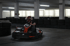 Ein Go-Kart-Fahrer in einem Helm und Anzug in einem Indoor-Go-Kart-Parcours.