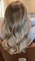 Rückansicht langer, gewellter Haare mit Balayage-Färbung von Dunkelblond zu Hellblond.