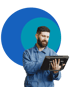 Mann mit Bart in blauem Arbeitsanzug hält ein Tablet in den Händen.