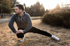 man stretches outdoors, incorporating BAHI therapy into his routine