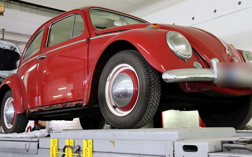 Oldtimer auf der Hebebühne zur Fahrzeugbewertung durch den KFZ-Sachverständigen