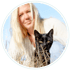 Schwarze Katze mit gelben Augen vor verschwommener Lisa-Maria und blauem Himmel in einem Kreis.