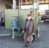 Mann mit brauner Jacke und Schiebermütze steht vor einem olivgrünen mobilen Reinigungsgerät.