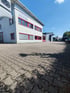 Zwei große, graue Industrieöfen mit blauen Akzenten und runden Türen stehen nebeneinander in einer Fabrikhalle.