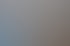 Zwei junge Männer sitzen an einem Schreibtisch vor einem Computerbildschirm und lächeln.