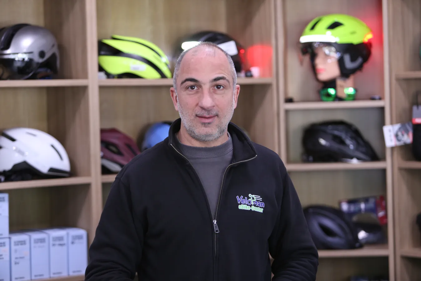 Vardan Abrahamyan vor dem Helmregal im Veloman eBike-Center