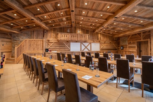 Heller Tagungsraum Almhütte aus Holz mit Tischen, Stühlen und Empore