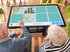 Zwei Personen spielen ein digitales Memory am Aktivtisch.