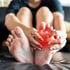 A person holding their foot, with pain highlighted on the heel.