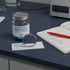 A pet supplement jar and its label next to an open lab notebook