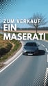 Silberner Maserati fährt auf einer Landstraße mit Bäumen und Feldern, darüber steht "MASERATI SCHUSTER & NASS GMBH".