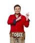 Schlager-Sänger Tobee im roten Hemd zeigt mit dem Finger nach oben vor einem Holzschild mit seinem Namen.