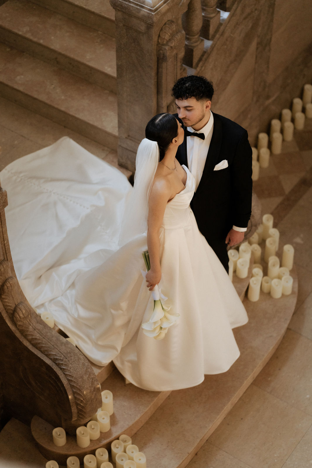 Brautpaar umarmt sich auf der Treppe, Brautkleid ausgebreitet, Schloss Garath.