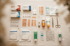 Flatlay einer Reiseapotheke mit Pflaster, Tabletten, Fieberthermometer und Sonnencreme – Reiseapotheke-Grundausstattung, Marien-Apotheke Mengen