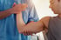 A chiropractor treating a patient's elbow or shoulder for joint pain.