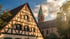 Luftaufnahme von Coburg mit dem Rathaus und der Stadtkirche St. Moriz, umgeben von Nebel bei Sonnenaufgang.