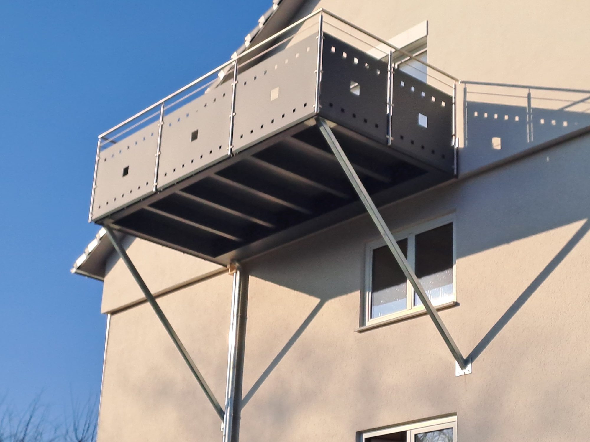 Anbaubalkon aus Stahl mit Lochblech-Brüstung und Edelstahl-Handlauf