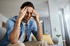 Man on sofa with hands on temples, showing vertigo and dizziness.
