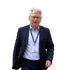 Ein Mann mit grauen Haaren, Brille und dunklem Anzug mit blauem Hemd und Ausweis.