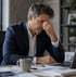 Man at desk appearing stressed, illustrating SS-31 peptide therapy support.