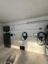 Zwei Wallboxen mit Kabeln und ein schwarzer Schrank in einer Garage mit Betonwänden und -boden.