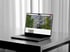 Ein offener Laptop mit einer Immobilien-Website auf einem Tisch vor einem Fenster.