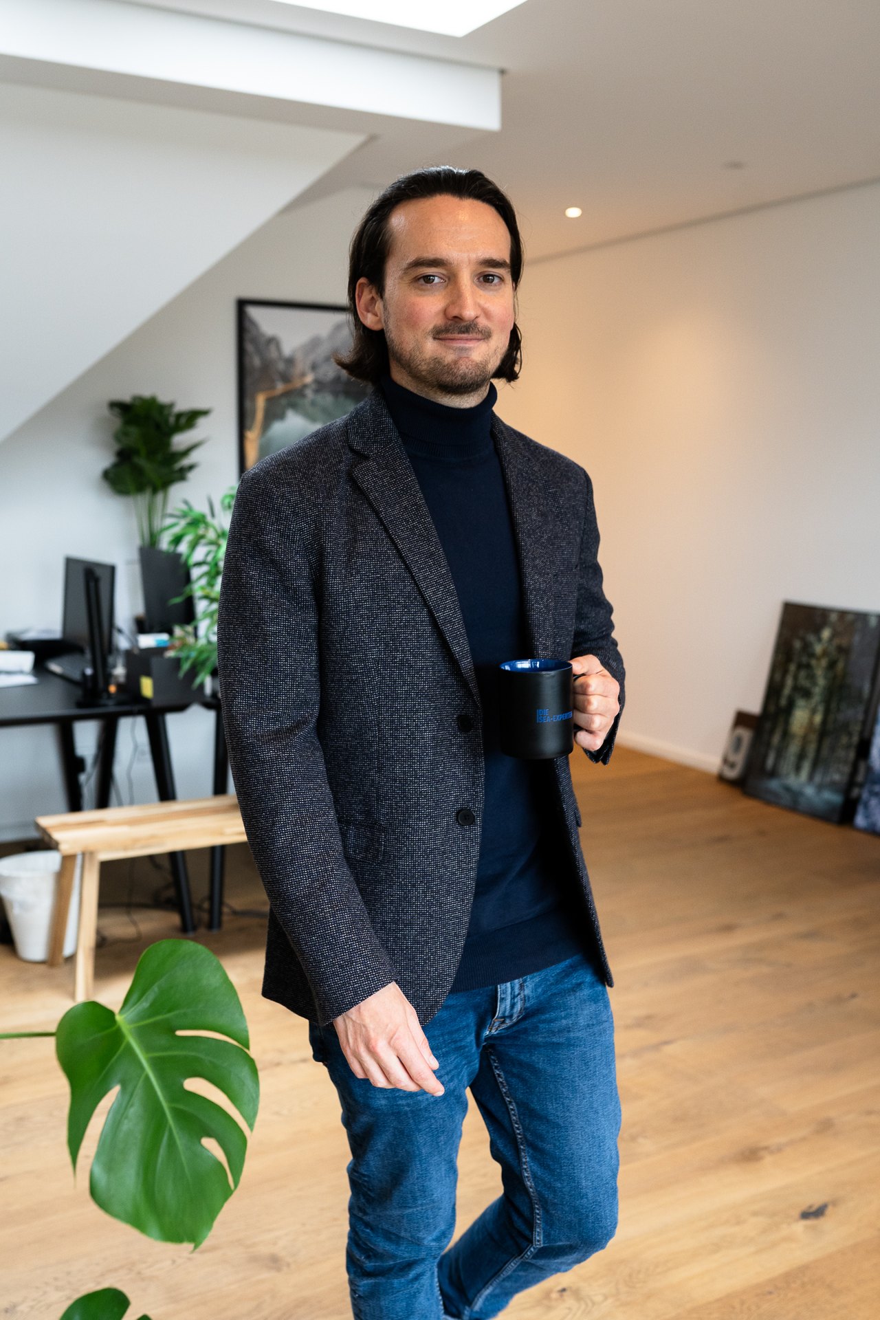 Daniel Rakus mit Kaffeetasse in seinem Büro