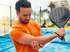 Man holds his elbow and paddle, needing sports injury treatment.