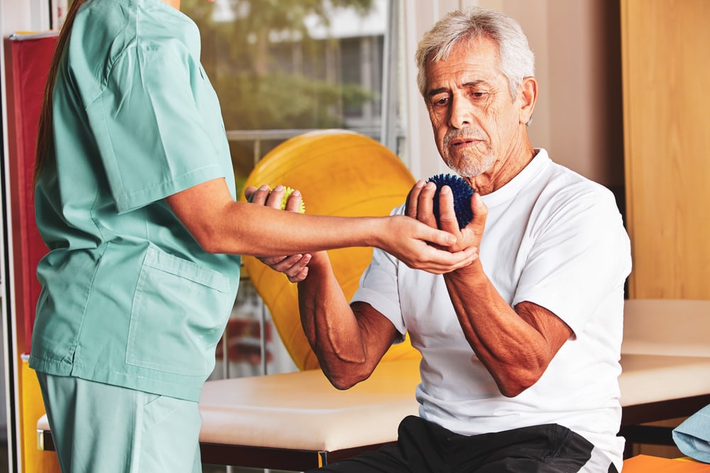 Therapeutin übt mit einem Patienten mit Igelbällen