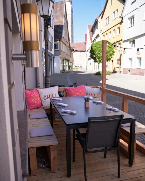 Sonniger Terrassentisch mit Sonnen- und CHILL-Kissen