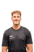 Mann mit kurzen, blonden Locken im schwarzen JAKO-Trikot mit SIGNAL IDUNA-Logo vor weißem Hintergrund.