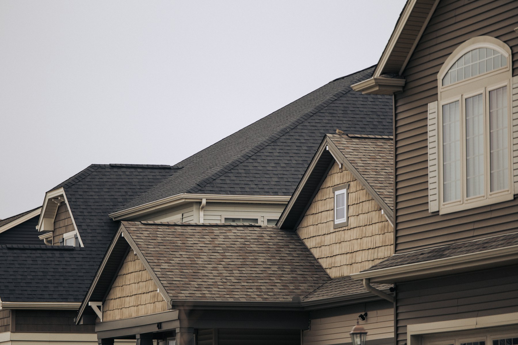 Row of shingle rooftops on suburban homes, roof warranty coverage for Fort Worth homeowners