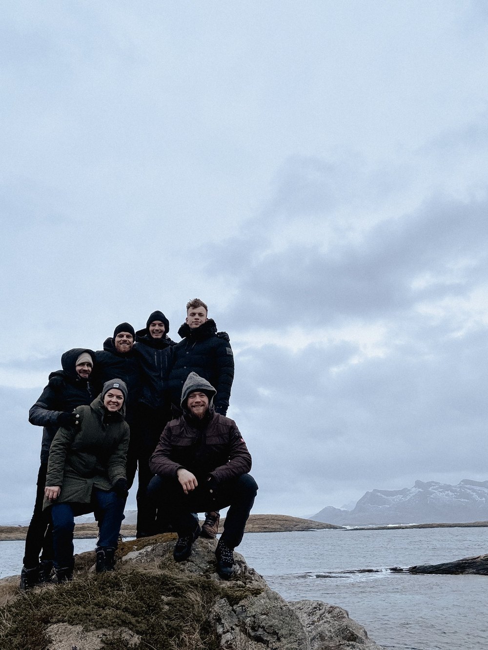 Gruppe steht auf einem Felsen am Meer