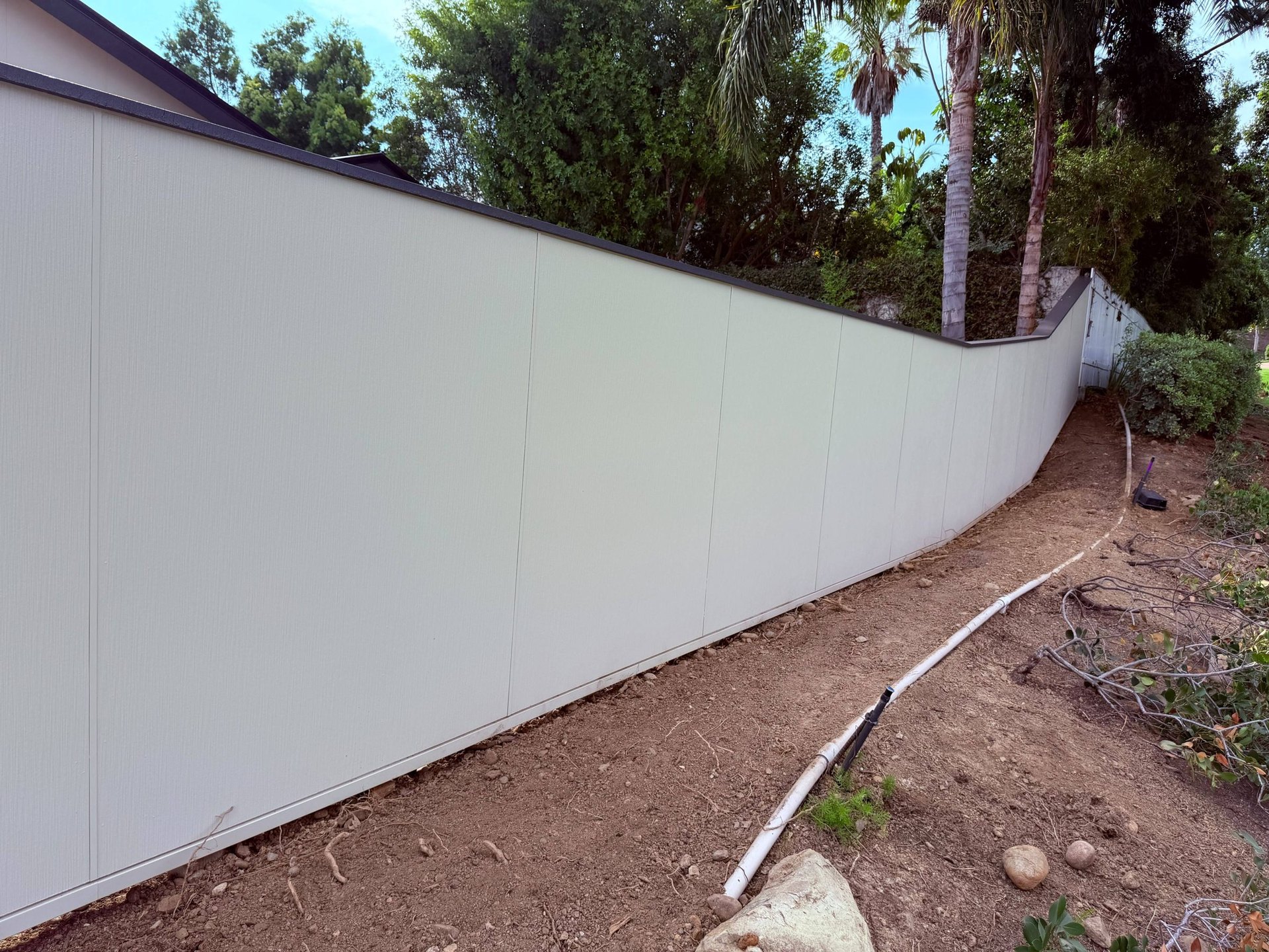 Fiber cement fence following the slope of a San Diego lot