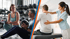 Ein Personal Trainer und eine Frau schauen auf ein Tablet im Fitnessstudio.