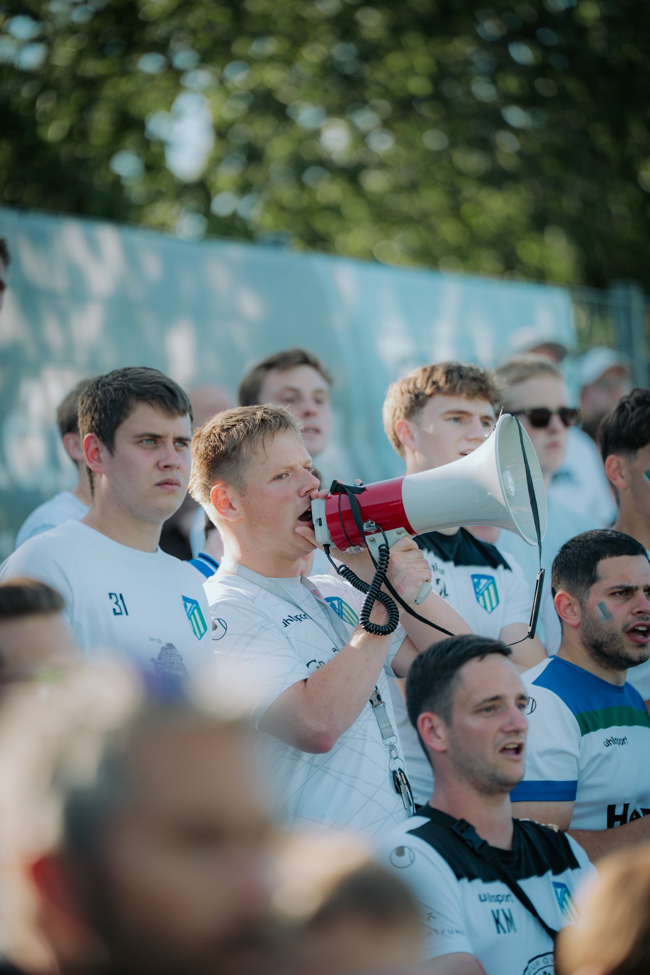Vorsaenger mit Megafon im Fanblock