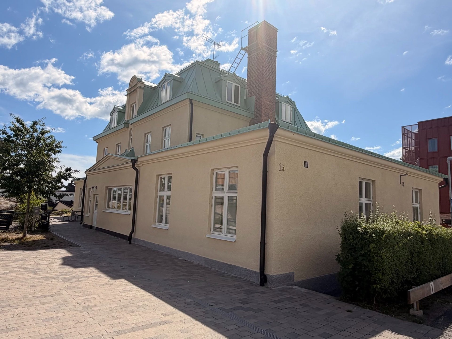 Nyrenoverad fasad på en putsad byggnad i solsken